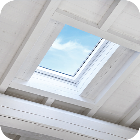 Lucernario in una casa con soffitto in legno bianco, che lascia entrare luce naturale e mostra un cielo azzurro.