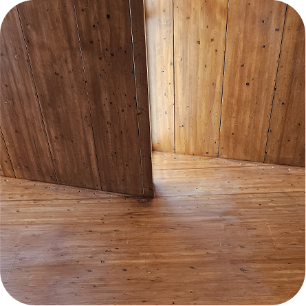 Pareti e pavimento in legno naturale, che mostrano la texture e le venature del legno, creando un ambiente caldo e accogliente.